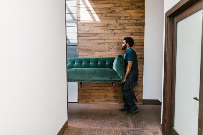 UW Moving mover carrying a sofa through a doorway